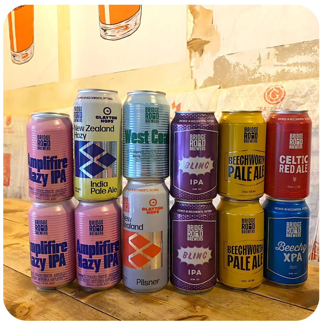 Collection of Bridge Road Brewing Company beer cans on a wooden surface.